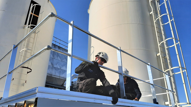 Mannen van Height Safety Support installeren permanente valbeveiliging.